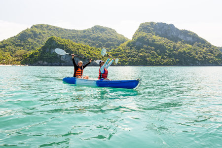 Two women are mother and daughter. Travel by boat with a kayak happy on the sea under the bright summer sky front of Ko Wua Ta lap islands at Mu Ko Ang Thong National Park, Surat Thani, Thailandの写真素材