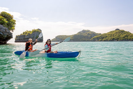 Two women are mother and daughter. Travel by boat with a kayak happy under the blue sky summer around Ko Phi view the beautiful nature of the sea and island, Mu Ko Ang Thong National Park, Surat Thani, Thailandの写真素材