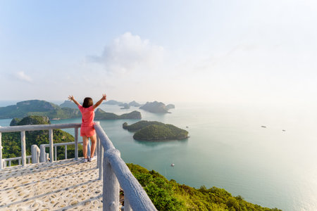 Woman tourist on the balcony is peak view point of Ko Wua Ta Lap island and beautiful nature landscape during sunrise over the sea in Mu Ko Ang Thong National Park, Surat Thani, Thailandの写真素材