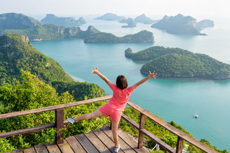 Woman tourist standing posing on the podium is peak view point of Ko Wua Ta Lap and beautiful nature landscape of island and sea in Mu Ko Ang Thong National Marine Park, Surat Thani, Thailandの写真素材