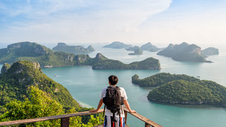 Man tourist with backpack are looking at the beautiful natural landscape of the sea on peak view point of Ko Wua Ta Lap island in Mu Ko Ang Thong National Park, Surat Thani, Thailand, 16:9 Widescreenの写真素材