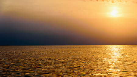 Beautiful nature landscape of colorful sky and warm orange light of the sun at sunset over the sea during summer for background in Thailand, 16:9 widescreenの写真素材