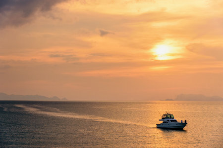 Speedboat for fishing on the sea returning to shore during the sunset in the midst of nature and the beautiful sky.の写真素材