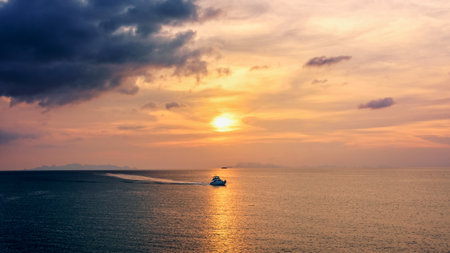 Speedboat for fishing on the sea returning to shore during the sunset in the midst of nature and the beautiful sky, 16:9 widescreenの写真素材