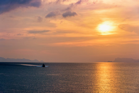 Speedboat for fishing on the sea returning to shore during the sunset in the midst of nature and the beautiful sky.の写真素材