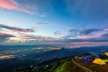 High view beautiful nature landscape of colorful sky during the sunrise, see the lights of the road and city from the campsite at Phu Thap Berk viewpoint, Phetchabun Province, Thailandの写真素材