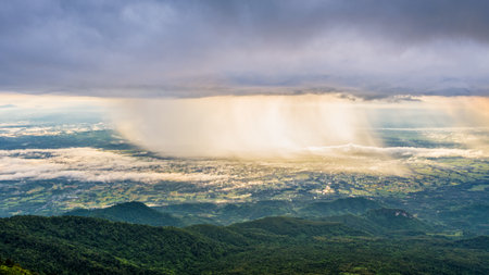High view beautiful nature landscape of the mountain sky forest and the rain is falling sunlight shining through is golden at Phu Thap Berk viewpoint, Phetchabun, Thailand, 16:9 wide screenの写真素材