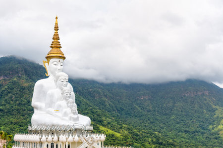 Buddha statue has large white five body on mountain surrounded by nature with cloud fog cover at Wat Phra That Pha Sorn Kaew Temple is a tourist attractions in Khao Kho, Phetchabun, Thailandの素材 [FY310119653590]