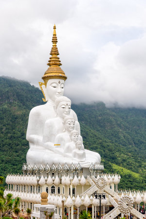 Buddha statue has large white five body on mountain surrounded by nature with cloud fog cover at Wat Phra That Pha Sorn Kaew Temple is a tourist attractions in Khao Kho, Phetchabun, Thailandの写真素材