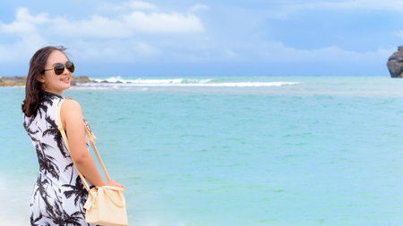 Beautiful nature landscape of the beach and sea in summer sky and woman tourist wearing sunglasse smiling with happiness on Tarutao island, Satun, Thailand, 16:9 widescreenの写真素材