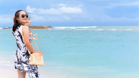 Beautiful nature landscape of the beach and sea in summer sky and woman tourist wearing sunglasse smiling with happiness on Tarutao island, Satun, Thailand, 16:9 widescreenの写真素材