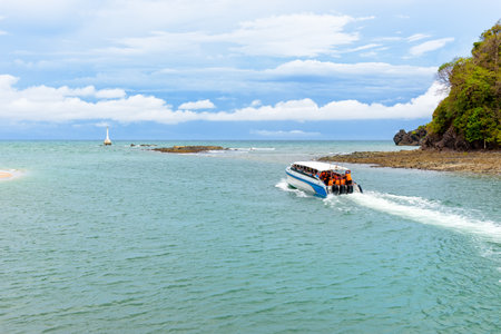 Tourists travel by speed boat, traveling on the sea leaving the coast of Tarutao island, beautiful nature in summer at Ko Tarutao National Park is a famous attractions of Satun Province, Thailandの写真素材