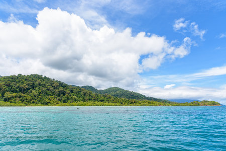 Beautiful tropical nature landscape of clear sea near the beach, green island, white cloud and blue...