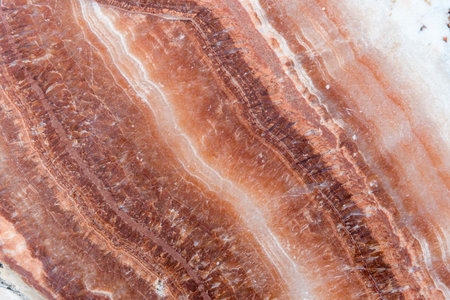 Smooth surface texture of stone, White and red line color striped wave pattern of marble, Strong structure durable nature of rock for abstract backgroundの写真素材