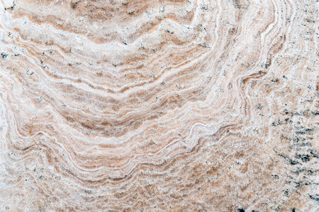 Smooth surface texture of stone, White beige or ecru color striped wave pattern of marble, Strong structure durable nature of rock for abstract backgroundの写真素材