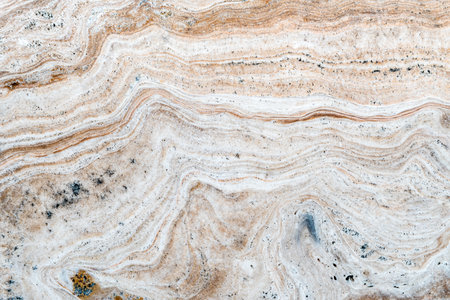Smooth surface texture of stone, White beige or ecru color striped wave pattern of marble, Strong structure durable nature of rock for abstract backgroundの写真素材