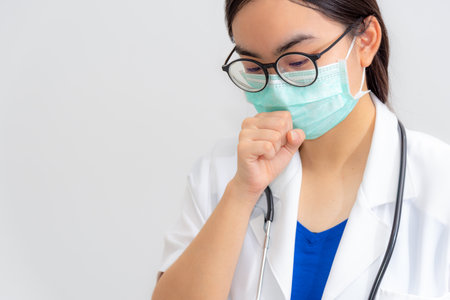 Asian young woman doctor coughing wear mask to safety Coronavirus, Medical cough is a danger signal a virus infection, Concept take care yourself is to help physician stop the epidemic Covid-19 virusの写真素材