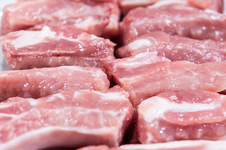 Close up top view pack pieces raw meat of pork loin on bone, fresh red pork with white fat of pork rib, Cut into pieces and put them in a rowの写真素材