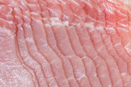 Closeup top view pieces raw meat of fresh pork slices are sliced into thin strips stacked on top of each otherの写真素材