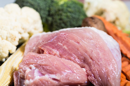 Close up piece fresh raw meat of pork and many vegetables are baby corn, broccoli flowers, mushroom, carrot, cauliflower Ingredients for food preparation cookingの写真素材