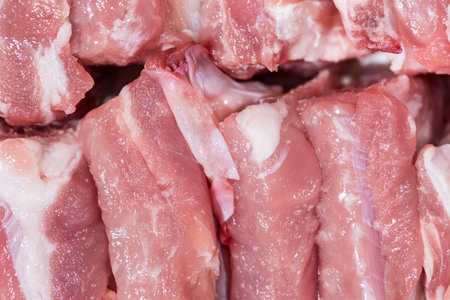 Close up top view pack pieces raw meat of pork loin on bone, fresh red pork with white fat of pork rib, Cut into pieces and put them in a rowの写真素材