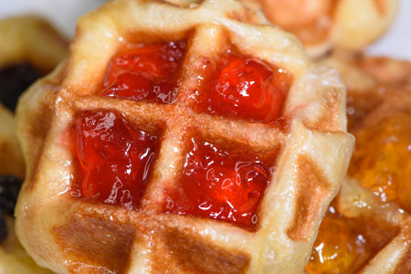 Close up of fresh waffles topped with delicious sweet strawberry jam and pineapple jam on top. Make homemade food or snacks at homeの写真素材