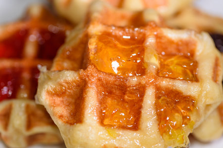 Close up of fresh waffles topped with delicious sweet pineapple jam on top. Making homemade food or dessert at homeの写真素材