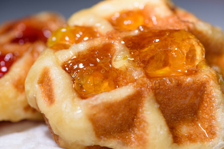 Close up of fresh waffles topped with delicious sweet pineapple jam on top. Making homemade food or dessert at homeの写真素材