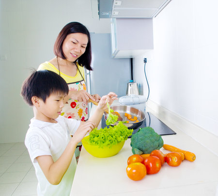 Asian mother and son cooking in the kitchenの写真素材