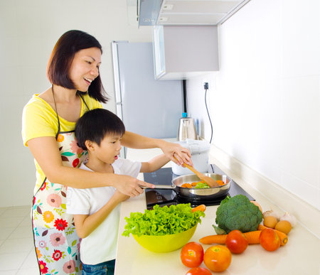 Asian mother and son cooking in the kitchenの写真素材