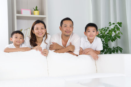 Asian family posing behind sofa.の写真素材