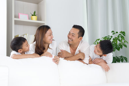 Asian family posing behind sofa.の写真素材