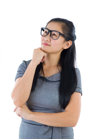 Businesswoman having a thought, looking up smiling happy. Portrait of beautiful Asian female model standing isolated on white background.の写真素材