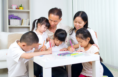 asian family doing school homework at living roomの写真素材