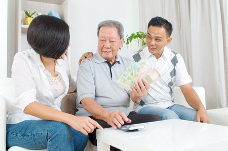 Asian senior man and children calculating money at their homeの写真素材