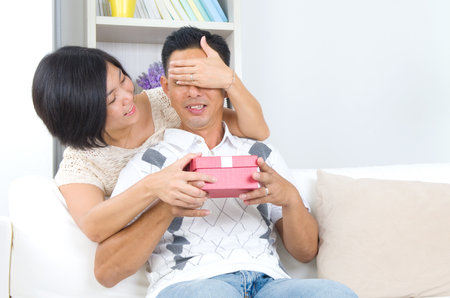 Asian girl surprises his boyfriend with a giftの写真素材