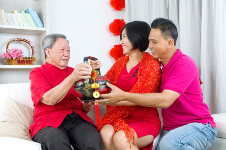 Asian childrern presenting gift basket to parent on chinese new yearの写真素材