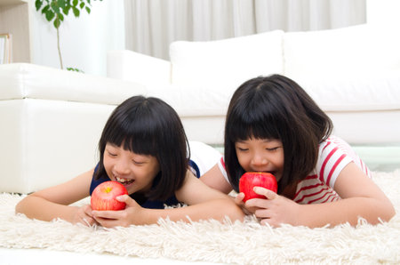 Lovely asian girls eating appleの写真素材