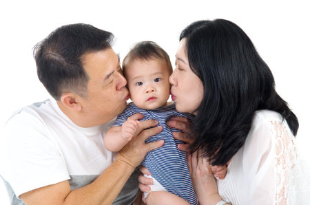 asian parent kissing their baby boyの写真素材