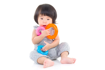 Cute asian girl sitting on the floor and playing toyの写真素材