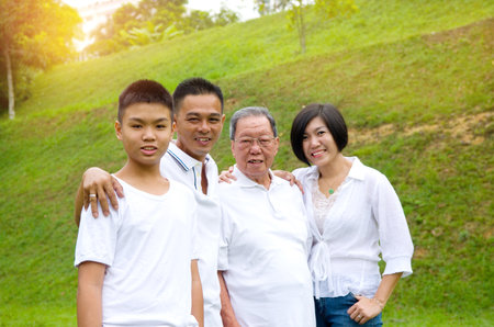 Portrait Of Multi-Generation Chinese Family Relaxing In Park Togetherの写真素材