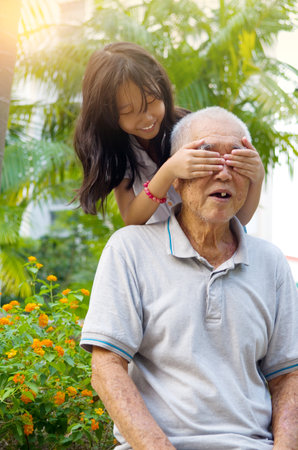 Asian Grandfather playing with his grandchildren at parkの写真素材