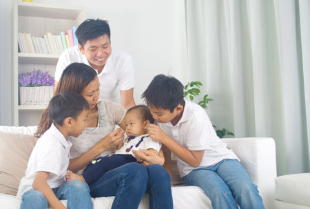 Asian family playing with babyの写真素材