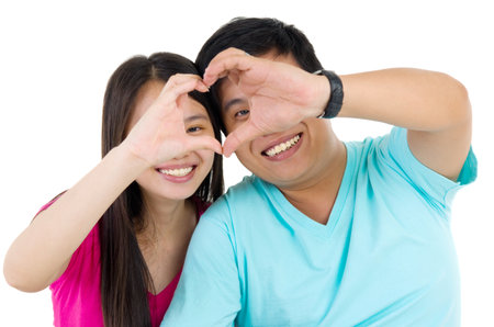 Young couple making heart shape by handsの写真素材
