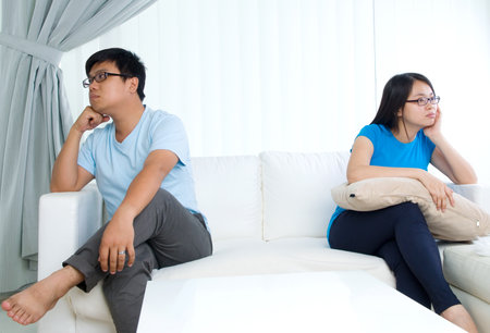 Asian young Couple having argument in the living roomの写真素材