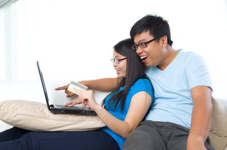 happy young couple with credit card and laptopの写真素材
