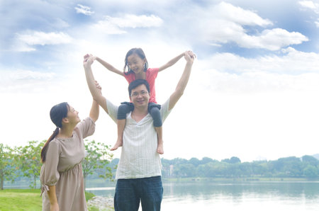 Happy Asian Family enjoying family time together in the parkの写真素材