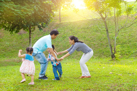 Asian family outdoor quality time enjoyment, asian people playing during beautiful sunset.の写真素材