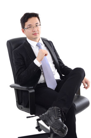Asian business man seated on chair, isolated on white background.の写真素材