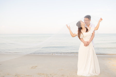Outdoor Bride and groom on the beach  in the evening.の写真素材